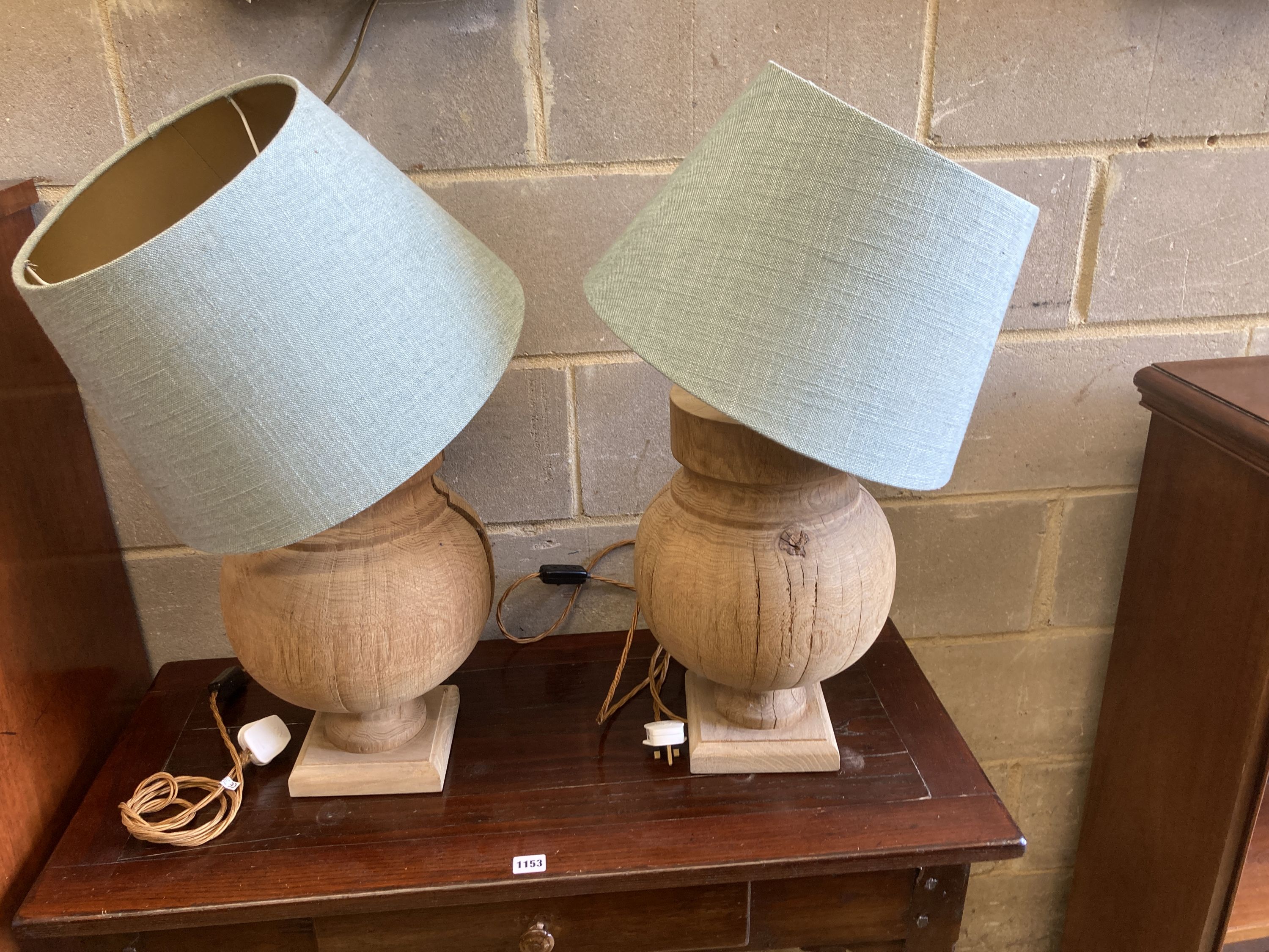 A pair of contemporary turned oak table lamps with shades, height 70cm